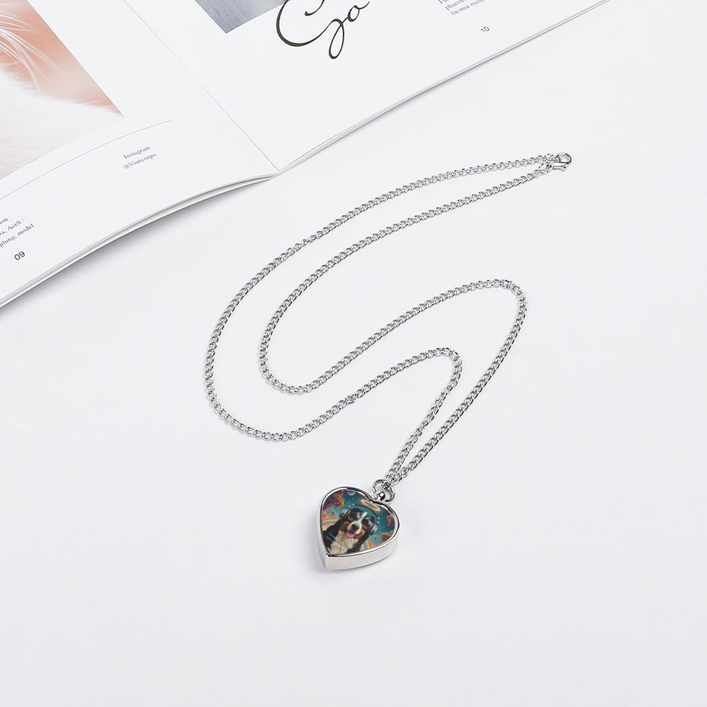Heart-shaped pendant necklace on a white surface with a magazine in the background