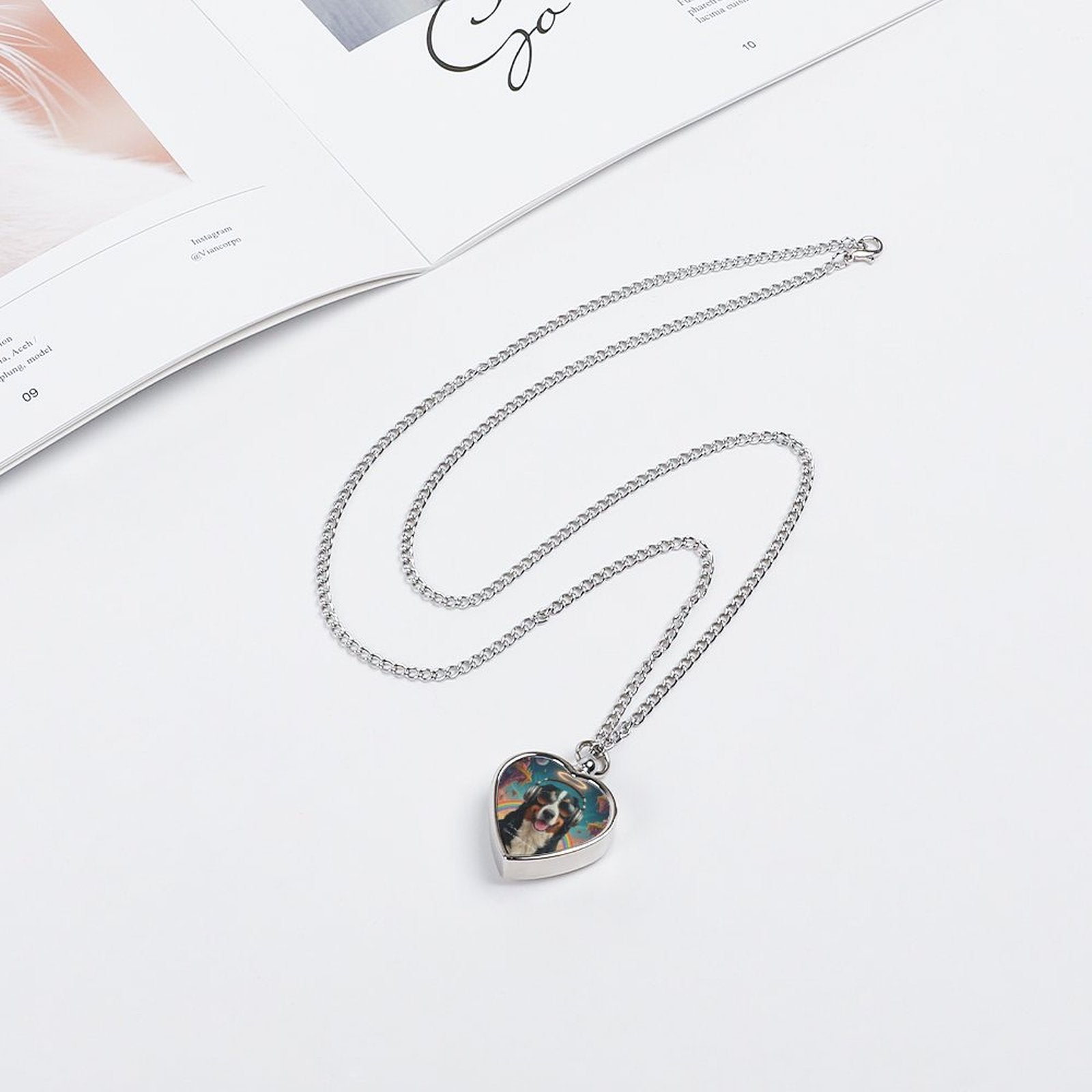 Heart-shaped pendant necklace on a white surface with a magazine in the background